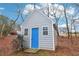 Gray shed with blue door in wooded backyard setting at 5220 Otter Creek Run, Cumming, GA 30040