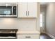 Close-up of the modern stainless steel microwave, tile backsplash, and quartz countertops at 746 Trevett Way, Marietta, GA 30062