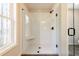 Elegant bathroom featuring frameless glass shower with black hardware and a window at 746 Trevett Way, Marietta, GA 30062