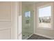 Bathroom with glass shower, window, and gray tile flooring at 754 Trevett Way, Marietta, GA 30062