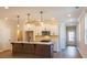 Open kitchen with stainless steel appliances, island, pendant lighting, and white cabinetry at 754 Trevett Way, Marietta, GA 30062