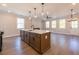 Spacious open living area with an island, ceiling fan, modern lighting, and ample windows at 754 Trevett Way, Marietta, GA 30062