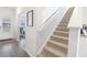 Modern staircase with carpet runner and light-filled entryway at 11555 Chatham Dr, Hampton, GA 30228