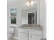 Bathroom with granite countertop, white cabinets and a large mirror at 3686 Lockaby Way, Lawrenceville, GA 30044