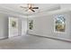 Main bedroom with carpet flooring, ceiling fan and multiple windows at 3686 Lockaby Way, Lawrenceville, GA 30044