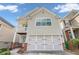 Two-story townhome with light beige vinyl siding, attached garage, and small balcony at 593 Shadow Valley Ct, Lithonia, GA 30058