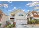 Two-story townhome with light beige vinyl siding, attached garage, and small balcony at 593 Shadow Valley Ct, Lithonia, GA 30058