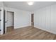 Spacious bedroom with wood-look flooring, an attached bathroom, and wainscoting at 4074 Hosch Retreat Dr, Buford, GA 30519