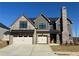 Beautiful two-story home featuring a brick and gray siding exterior and a large brick chimney at 4074 Hosch Retreat Dr, Buford, GA 30519