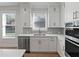 Modern kitchen with white cabinets, sink, and dishwasher at 4074 Hosch Retreat Dr, Buford, GA 30519