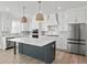 Modern kitchen with white cabinets, large island, and stainless steel appliances at 4074 Hosch Retreat Dr, Buford, GA 30519