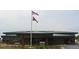 One-story brick building with dark metal roof and two flags at 11583 Chatham Dr, Hampton, GA 30228