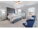 Spacious main bedroom with tufted headboard, gray carpet, and ceiling fan at 11583 Chatham Dr, Hampton, GA 30228