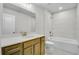 Modern bathroom with tub, single vanity, and tiled walls at 134 Briargate Dr, Johns Creek, GA 30097