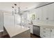 Charming kitchen featuring white cabinets, stainless steel appliances, modern lighting, and a bright window at 2716 Battle Sw Trl, Marietta, GA 30064