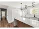 Well-lit kitchen featuring a large island, stainless steel appliances, white cabinetry, modern fixtures, and wood floors at 2716 Battle Sw Trl, Marietta, GA 30064