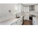 Well-lit kitchen featuring a large countertop, stainless steel appliances, white cabinetry, and modern fixtures at 2716 Battle Sw Trl, Marietta, GA 30064