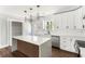 Well-lit kitchen featuring a large island, stainless steel appliances, white cabinetry, and modern fixtures at 2716 Battle Sw Trl, Marietta, GA 30064