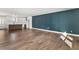 Open-concept space featuring hardwood floors, a kitchen with an island, and a striking blue accent wall at 2716 Battle Sw Trl, Marietta, GA 30064