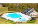 Aerial view of the community pool and clubhouse with a deck and surrounding greenery at 13561 Whitman Ln, Covington, GA 30014