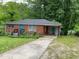 Brick ranch house with driveway, mature trees, and a landscaped yard at 2496 Old Hapeville Sw Rd, Atlanta, GA 30315