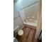 Bathroom with tub and toilet, featuring light wood flooring at 894 Glynn Oaks Dr, Clarkston, GA 30021