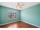 This bedroom features hardwood floors, a ceiling fan, and natural light from a window at 1379 Paddocks Way, Powder Springs, GA 30127