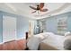 Well-lit main bedroom with hardwood floors, tray ceiling, and a view into the ensuite bathroom at 1379 Paddocks Way, Powder Springs, GA 30127