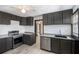 Well-lit kitchen featuring stainless steel appliances, gray cabinets and granite countertops at 1490 Broad Ne St, Conyers, GA 30012