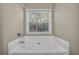 Bathroom with corner soaking tub and window at 1538 Park Grove Dr, Lawrenceville, GA 30046