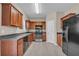 Bright kitchen with wood cabinets, black appliances, light gray flooring, and stone countertops at 1538 Park Grove Dr, Lawrenceville, GA 30046