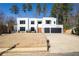 Modern white house with a three-car garage and landscaped lawn at 2220 Meadowvale Ne Dr, Atlanta, GA 30345