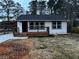 Newly renovated home with white siding, black windows and a wooden deck at 1840 Judy Se Cir, Marietta, GA 30060