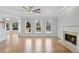 Cozy living room with fireplace, hardwood floors, ceiling fan, and natural light at 4974 Dovecote Trl, Suwanee, GA 30024