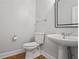 Neat half bath with white fixtures, decorative mirror, and hardwood floors at 4974 Dovecote Trl, Suwanee, GA 30024