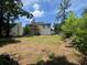 Spacious backyard with mature trees behind a two story home at 114 Jousters Ln, Lawrenceville, GA 30044