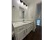 Bathroom vanity with quartz countertop and modern lighting at 114 Jousters Ln, Lawrenceville, GA 30044