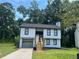 Two-story house with white siding, black window frames and a gray garage door at 114 Jousters Ln, Lawrenceville, GA 30044