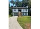 Newly renovated two-story house featuring white siding and a gray garage door at 114 Jousters Ln, Lawrenceville, GA 30044