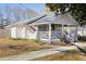 White cottage with a wraparound porch and American flag at 3170 New Macland Rd, Powder Springs, GA 30127