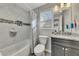 Bright bathroom with a marble tiled wall and shower, gray vanity with granite countertop and modern fixtures at 1775 Jody Ne Dr, Marietta, GA 30066