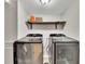 Well-lit laundry room featuring modern front loading washer and dryer with overhead shelving at 1775 Jody Ne Dr, Marietta, GA 30066