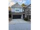 Two-story townhome with a two-car garage and landscaping at 3144 Spicy Cedar Ln, Lithonia, GA 30038