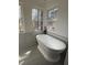 Bathroom featuring a soaking tub, large windows and marble tile at 3422 Sweetwater Dr, Lawrenceville, GA 30044