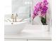Elegant bathroom features a white vessel sink and purple orchid at 3000 Leeds Garden Ln, Alpharetta, GA 30022