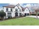 Stunning two-story house with a white exterior, black accents, and a beautifully landscaped lawn at 3000 Leeds Garden Ln, Alpharetta, GA 30022