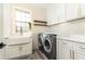Modern laundry room with white cabinets, hexagon tile, and a large utility sink at 3000 Leeds Garden Ln, Alpharetta, GA 30022