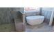 Elegant bathroom with a freestanding tub, a window, and marble-look tile at 4515 Aiden Way, Cumming, GA 30041
