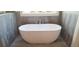 A close up of the stylish freestanding tub in the bathroom, tiled in gray at 4515 Aiden Way, Cumming, GA 30041
