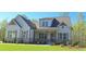 Beautiful home with gray siding, brick foundation, symmetrical windows and an inviting front porch at 4515 Aiden Way, Cumming, GA 30041